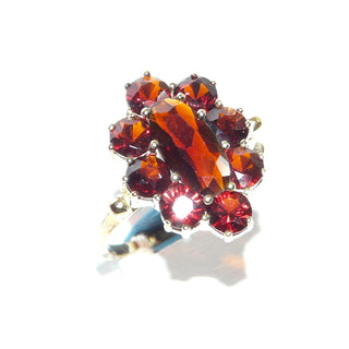 Vintage-Einzelstück, Granatring aus 333 Gold mit einem langovalen & 8 runden, funkelnd facettierten Granate in schöner Farbe, ovale Rosette in Krappenfassungen, 2 Kügelchen als Übergang zur Ringschiene, Ringweite 54,5, um 1960, Friedrich Hutte Pforzheim - Goldschmiede Danilo