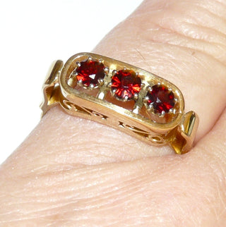 Vintage-Einzelstücke, handgefertigter Granatring aus 585 Gold mit 4 runden, handgeschliffenen Altschliff-Granaten, mit Krappenfassungen aus Weißgold, Granate in einer Reihe quer nebeneinander in einem geraden Oval mit Stöppeln eingefügt, Seitenflächen mit Schnörkeln, Ringweite 56,5, um 1960 Goldschmiede Danilo