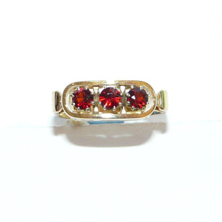 Vintage-Einzelstücke, handgefertigter Granatring aus 585 Gold mit 4 runden, handgeschliffenen Altschliff-Granaten, mit Krappenfassungen aus Weißgold, Granate in einer Reihe quer nebeneinander in einem geraden Oval mit Stöppeln eingefügt, Seitenflächen mit Schnörkeln, Ringweite 56,5, um 1960 Goldschmiede Danilo