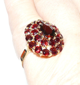 Vintage-Einzelstück, großer Granatring in 3 leicht gewölbten Ebenen aus 585 Gold, ein größerer ovaler & 24 kleinere runde, funkelnd facettierte Altschliff-Granate in schöner Farbe bilden eine ovale Rosette, Cocktailring mit einem Drahtkörbchen & Krappenfassungen, Ringweite 54, um 1960 - Goldschmiede Danilo