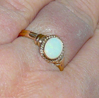 Einzelstück, alte Handarbeit, Vintage-Ring aus 585 Roségold mit einem grün schillernden, breit-ovalen, australischen Jelly-Opal, poliert, sicher eingefaßt in einer Zarge mit Kordelumrandung, Ringweite 56, um 1930 (Da es sich bei Vintage-Schmuck um „Schmuck mit Vergangenheit“ handelt, ist es möglich, daß verarbeitete Edelsteine eventuell leichte Tragespuren aufweisen, die erst bei näherer Betrachtung sichtbar werden. Dies ist bei 30-120 Jahre alten Pretiosen ein Zeichen ihrer Geschichte.)