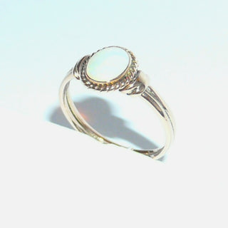 Einzelstück, alte Handarbeit, Vintage-Ring aus 585 Roségold mit einem grün schillernden, breit-ovalen, australischen Jelly-Opal, poliert, sicher eingefaßt in einer Zarge mit Kordelumrandung, Ringweite 56, um 1930 (Da es sich bei Vintage-Schmuck um „Schmuck mit Vergangenheit“ handelt, ist es möglich, daß verarbeitete Edelsteine eventuell leichte Tragespuren aufweisen, die erst bei näherer Betrachtung sichtbar werden. Dies ist bei 30-120 Jahre alten Pretiosen ein Zeichen ihrer Geschichte.)