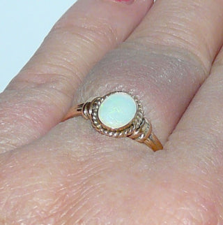 Einzelstück, alte Handarbeit, Vintage-Ring aus 585 Roségold mit einem grün schillernden, breit-ovalen, australischen Jelly-Opal, poliert, sicher eingefaßt in einer Zarge mit Kordelumrandung, Ringweite 56, um 1930 (Da es sich bei Vintage-Schmuck um „Schmuck mit Vergangenheit“ handelt, ist es möglich, daß verarbeitete Edelsteine eventuell leichte Tragespuren aufweisen, die erst bei näherer Betrachtung sichtbar werden. Dies ist bei 30-120 Jahre alten Pretiosen ein Zeichen ihrer Geschichte.)