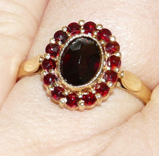 Vintage-Einzelstück, antiker Granatring aus 375 Gold mit einem ovalen & 14 kleinen runden Böhmischen Granaten, alle im Sternschliff, England Manufaktur G.H.Johnstone & Co. Birmingham, ovale Rosette aus Krappen- & einer Zargenfassung mit Millesgriffes-Rand, Ringweite 59,5, Edwardiansche Epoche 1905-25 - Goldschmiede Danilo