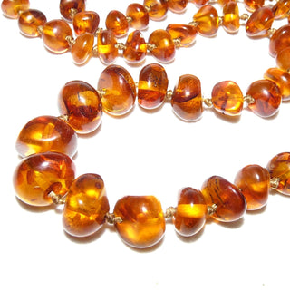 handgefädeltes Einzelstück, Bernstein-Kette aus polierten, unregelmäßigen, dicken Nuggets in Linsenform, dunkleres Cognac-braun mit schönen Einschlüssen, im Verlauf durchgeknotet, Verschluß aus Gold-Doublé, Gesamtlänge 65 cm -	Nur erhältlich im Onlineshop von Juwelier & Goldschmiede Danilo!