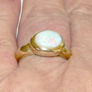 Einzelstück, breiter Ring aus massivem 585 Gelbgold mit einem weißen, kristallinen, australischen Opal-Cabochon. Das schillernde Oval ist interessant quer zum Finger eingearbeitet, der große Stein schillert herrlich in allen Farben, aber mit besonders viel Rot Der Ring ist poliert und der Stein sicher in einer breiten Zargenfassung eingefaßt, Ringweite 59 - Unikate und Pretiosen nur erhältlich im Onlineshop der Goldschmiede Danilo!