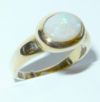 Einzelstück, breiter Ring aus massivem 585 Gelbgold mit einem weißen, kristallinen, australischen Opal-Cabochon. Das schillernde Oval ist interessant quer zum Finger eingearbeitet, der große Stein schillert herrlich in allen Farben, aber mit besonders viel Rot Der Ring ist poliert und der Stein sicher in einer breiten Zargenfassung eingefaßt, Ringweite 59 - Unikate und Pretiosen nur erhältlich im Onlineshop der Goldschmiede Danilo!