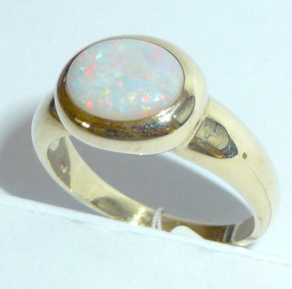 Einzelstück, breiter Ring aus massivem 585 Gelbgold mit einem weißen, kristallinen, australischen Opal-Cabochon. Das schillernde Oval ist interessant quer zum Finger eingearbeitet, der große Stein schillert herrlich in allen Farben, aber mit besonders viel Rot Der Ring ist poliert und der Stein sicher in einer breiten Zargenfassung eingefaßt, Ringweite 59 - Unikate und Pretiosen nur erhältlich im Onlineshop der Goldschmiede Danilo!