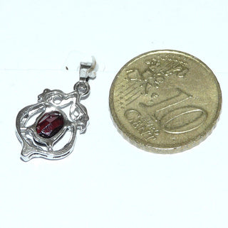 Einzelstück, filigraner Granat-Anhänger aus 835 Silber mit einem ovalen, funkelnd facettierten Granat im typischen Granat-Rot, sicher gehalten in einem 4-Krapper-Chaton, floral umrahmt von Schnörkeln + Kugeln. -	Nur erhältlich bei www.danilogold-shop.de