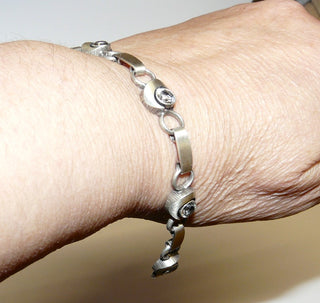 Einzelstück, Nordform-Armband aus 925 Silber mit 6 runden Elementen mit Bergkristall Nordform-Design, 18,5 cm, seidenmatt, in den Tiefen geschwärzt. Die gesamte skandinavische / finnische Nordform-Kollektion ist so designt, daß fast alle Schmuckstücke miteinander kombinierbar sind. Besonders gut zu diesem Schmuckstück paßen die Ohr-Clips Nord 0063 + Ring Nord 0031 -	Unikate und Pretiosen nur erhältlich im Onlineshop der Goldschmiede Danilo!