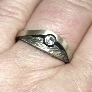 Einzelstück, Nordform-Design, Nordform-Ring "großer Bogen" aus 925 Silber mit einem runden, funkelnd facettierten Bergkristall, seidenmatt, in den Tiefen geschwärzt, verstellbare Ringweite bis ca. 63. Die gesamte skandinavische / finnische Nordform-Kollektion ist so designt, daß fast alle Schmuckstücke miteinander kombinierbar sind. Besonders gut zu diesem Schmuckstück paßt Nord 0022 + Collier Nord 0004. - Nur erhältlich bei www.danilogold-shop.de
