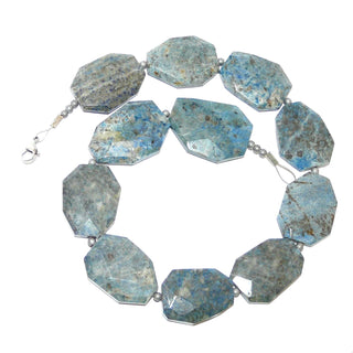 hellgraublaues Einzelstück, Statement-Edelsteinkette, Lapislazulikette aus facettierten flachen 8-Ecken, je ca. 40mm x 27mm, als Zwischenteile kleine graue Hämatit-Kugeln, Verschluß Karabiner aus Metall, Länge 50cm, auf Stahlseide aufgereiht - Goldschmiede Danilo