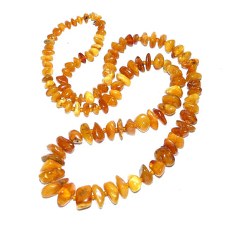 antikes Einzelstück, handgeschliffene Vintage-Bernstein-Kette aus polierten Chips / Splittern im Verlauf ungeknotet aufgereiht mit kleinen Mini-Kügelchen als Abstandshalter für einen besonders schönen Fall am Hals, hell-honigfarbener Butterscotch, ohne Verschluß, Gesamtlänge 68 cm, um 1930 -	Nur erhältlich im Onlineshop von Juwelier & Goldschmiede Danilo!