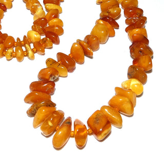 antikes Einzelstück, handgeschliffene Vintage-Bernstein-Kette aus polierten Chips / Splittern im Verlauf ungeknotet aufgereiht mit kleinen Mini-Kügelchen als Abstandshalter für einen besonders schönen Fall am Hals, hell-honigfarbener Butterscotch, ohne Verschluß, Gesamtlänge 68 cm, um 1930 -	Nur erhältlich im Onlineshop von Juwelier & Goldschmiede Danilo!