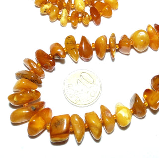 antikes Einzelstück, handgeschliffene Vintage-Bernstein-Kette aus polierten Chips / Splittern im Verlauf ungeknotet aufgereiht mit kleinen Mini-Kügelchen als Abstandshalter für einen besonders schönen Fall am Hals, hell-honigfarbener Butterscotch, ohne Verschluß, Gesamtlänge 68 cm, um 1930 -	Nur erhältlich im Onlineshop von Juwelier & Goldschmiede Danilo!