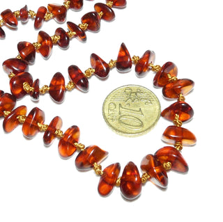 handgefädeltes Einzelstück, Bernstein-Kette aus polierten, unregelmäßige Linsen-Nuggets, im Verlauf durchgeknotet aufgefädelt, dunkleres Cognac-rotbraun mit Einschlüsse, Verschluß aus Metall, Gesamtlänge 76 cm - Nur erhältlich im Onlineshop von Juwelier & Goldschmiede Danilo!