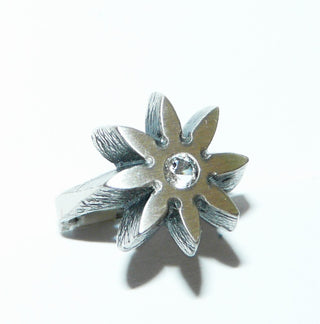 Einzelstück, Nordform-Design Bergkristall-Ring "Blüten-Stern" aus 925 Silber, mit einem runden, funkelnd facettierten Bergkristall, seidenmatt, in den Tiefen geschwärzt, verstellbare Ringweite bis ca. 63. Anlaufgeschützt. Die gesamte skandinavische / finnische Nordform-Kollektion ist so designt, daß fast alle Schmuckstücke miteinander kombinierbar sind. Besonders gut zu diesem Schmuckstück paßt Nord 0022.  -	Finnlandschmuck bei Goldschmiede Danilo