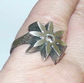 Einzelstück, Nordform-Design Bergkristall-Ring "Blüten-Stern" aus 925 Silber, mit einem runden, funkelnd facettierten Bergkristall, seidenmatt, in den Tiefen geschwärzt, verstellbare Ringweite bis ca. 63. Anlaufgeschützt. Die gesamte skandinavische / finnische Nordform-Kollektion ist so designt, daß fast alle Schmuckstücke miteinander kombinierbar sind. Besonders gut zu diesem Schmuckstück paßt Nord 0022.  -	Finnlandschmuck bei Goldschmiede Danilo