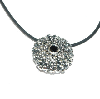 rundes Einzelstück. Silberanhänger "Seeigel" aus massiv 925 Silber, in den Tiefen geschwärzt, hell polierte Noppen, aufgewölbt mit einem facettierten schwarzen Zirkonia & einer verdeckten Schlaufe - Goldschmiede Danilo