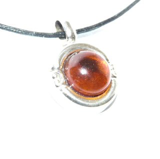 rundes Einzelstück, Vintage Bernsteinanhänger aus 835 Silber mit einem klaren natürlichen honigfarbenen Bernstein-Cabochon mit dunklem Einschluss, wulstiger Rand mit zwei Schnörkeln, Andreas Daub Pforzheim um 1960 - Goldschmiede Danilo