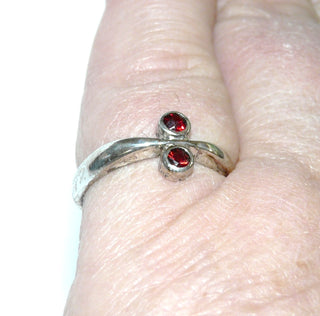 Einzelstück, schlichter Granat-Ring in Zungenschienen-Optik aus 835 Silber mit zwei runden, funkelnd facettierten Granaten in schönem typischen Granat-Rot Farbe, verstellbare Ringweite bis ca. 57. Paßt zu Brosch-Anhänger An 0224 sowie An 0228 + Ohrschmuck Ohr 0112. (Kennen Sie Ihre Ringweite? Dann geben Sie diese bei der Bestellung an, und wir stellen diese Weite vorab für Sie ein!) -	Nur erhältlich im Onlineshop von Juwelier & Goldschmiede Danilo!