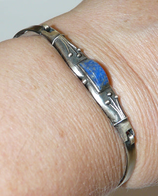 Einzelstück, schmale, dezente Armspange "Grasgarbe" aus 925 Silber mit einem blauen Lapislazuli als gewölbte Rolle und einer floralen Belötung, die an einen Strauß Gräsern erinnert, in den Tiefen geschwärzt + seidenmatt, Einhakerverschluß, Innenumfang ca. 17 cm -	Einzelstücke nur erhältlich bei www.danilogold-shop.de