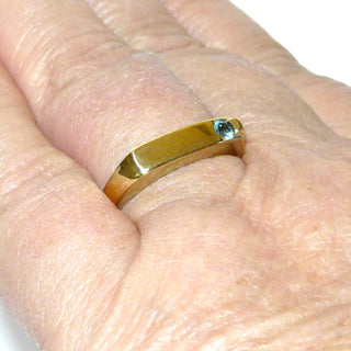 schlichtes Einzelstück, Blautopasring als schmaler Bandring, auch als Herrenring aus 333 Gold, ein runder, funkelnd facettierter, aquamarinblauer Edeltopas, eingelassen dezent gefaßt, schmale Gravurfläche, Ringweite 60 - Goldschmiede Danilo