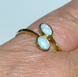 Einzelstück, zarter Ring aus 333 Gelbgold mit 2 weißen kristallinen, in allen Farben, mit viel Rot schillernden, australischen Opalen, die ovalen Cabochons sind versetzt angeordnet, poliert, Zargenfassungen, Ringweite 54 -	Nur erhältlich im Onlineshop von Juwelier & Goldschmiede Danilo!