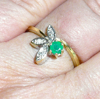 Einzelstück, zarter Smaragd-Ring "halbe Blüte" aus 585 Gelbgold mit einem runden, facettierten Smaragd in schöner Farbe und typischen Einschlüssen in 6-Krapper-Chaton sowie 3 Diamanten von zusammen 0,03 Karat in je einem Blättchen eingefaßt, Ringweite 57. -	Nur erhältlich bei www.danilogold-shop.de