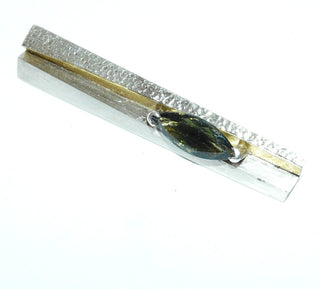 handgefertigtes Einzelstück, zweifarbige Unikat-Brosche + Anhänger aus 925 Silber + 999 Feingold in Keum-Boo-Technik gefertigt, mit 2,72 Karat flaschengrüner Moldavit (Meteoriten-Glas), facettiertes Navette, Kugelsicherung, gefalteter Stab, Oberfläche seidenmatt + teilweise Hammerschlag. -	Handgefertigtes Unikat! Nur im Onlineshop von Juwelier & Goldschmiede Danilo!